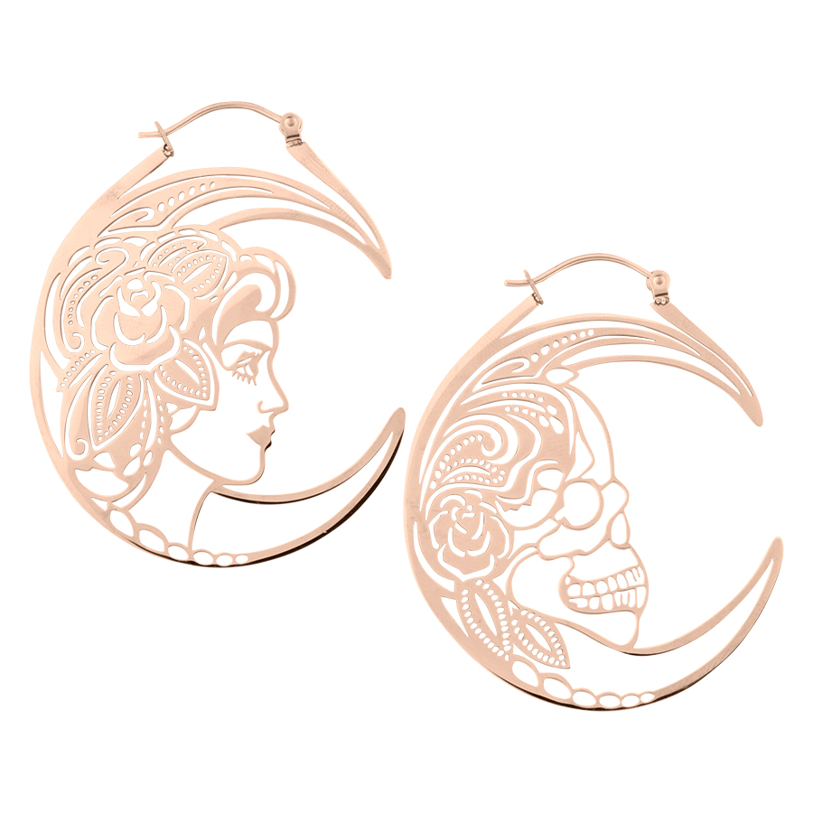 Due orecchini in oro rosa con design di teschio e figura femminile su sfondo bianco
