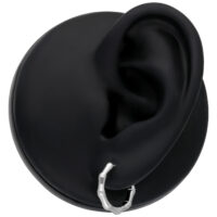 Orecchini in bambù argento su modello d'orecchio nero su sfondo neutro