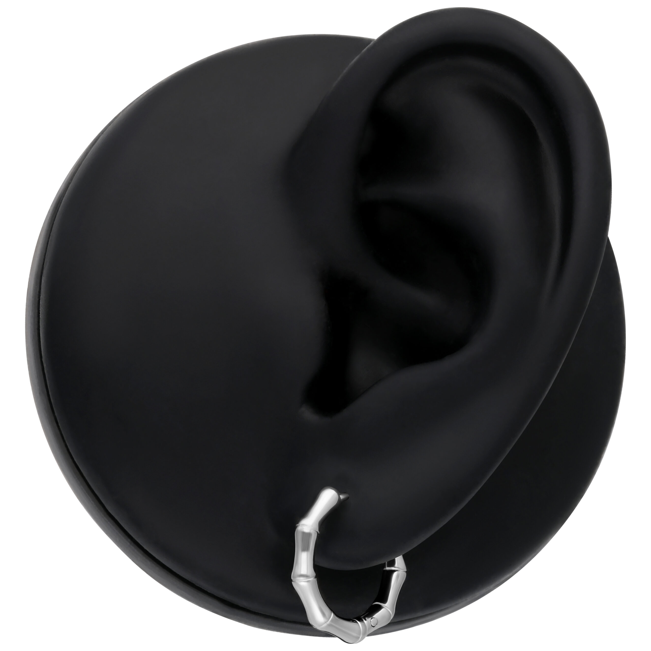 Orecchini in bambù argento su modello d'orecchio nero su sfondo neutro