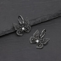 Orecchini a farfalla neri in acciaio chirurgico con cristallo chiaro su sfondo grigio