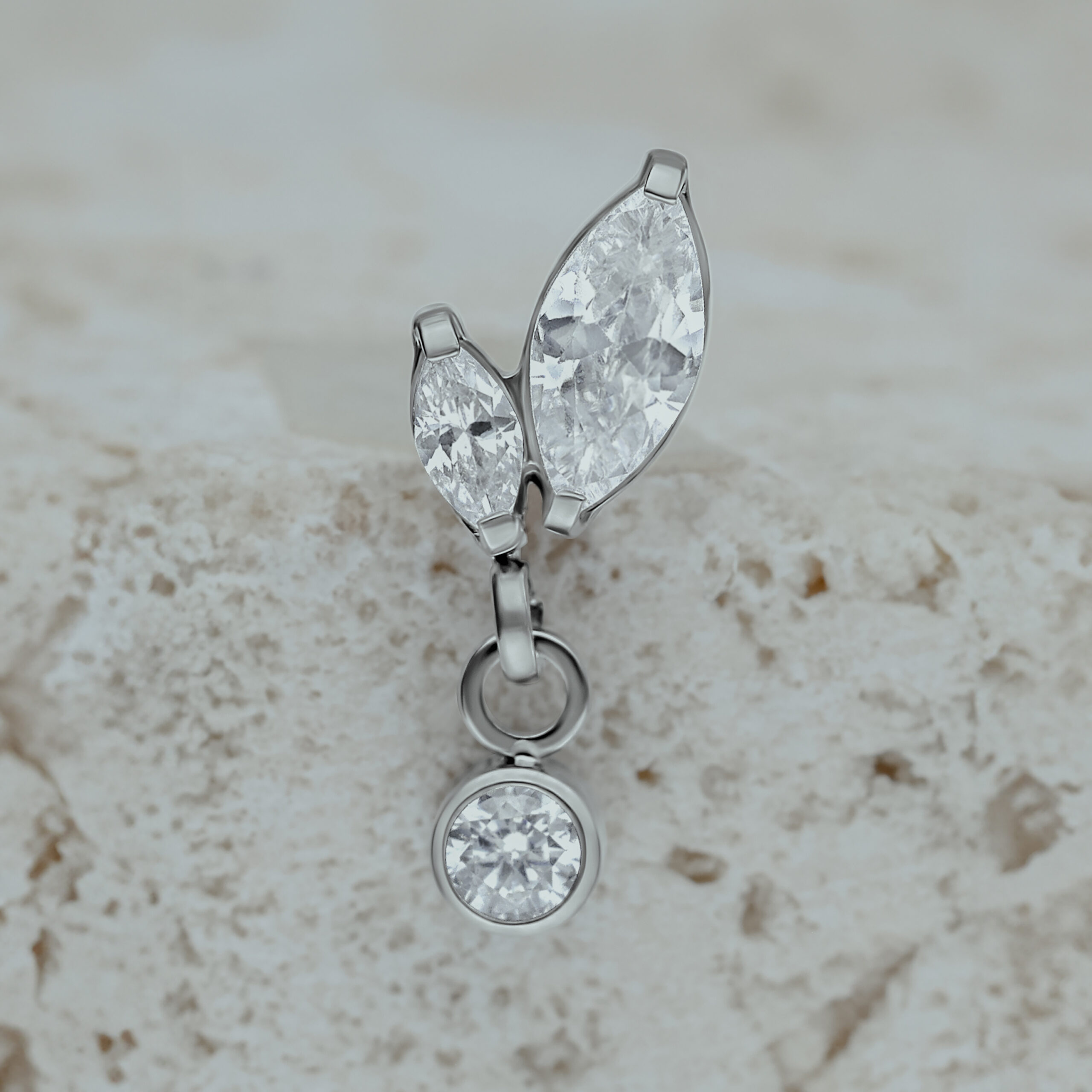 Accessorio Push Fit in argento con due pietre marquise e un pendente su sfondo chiaro