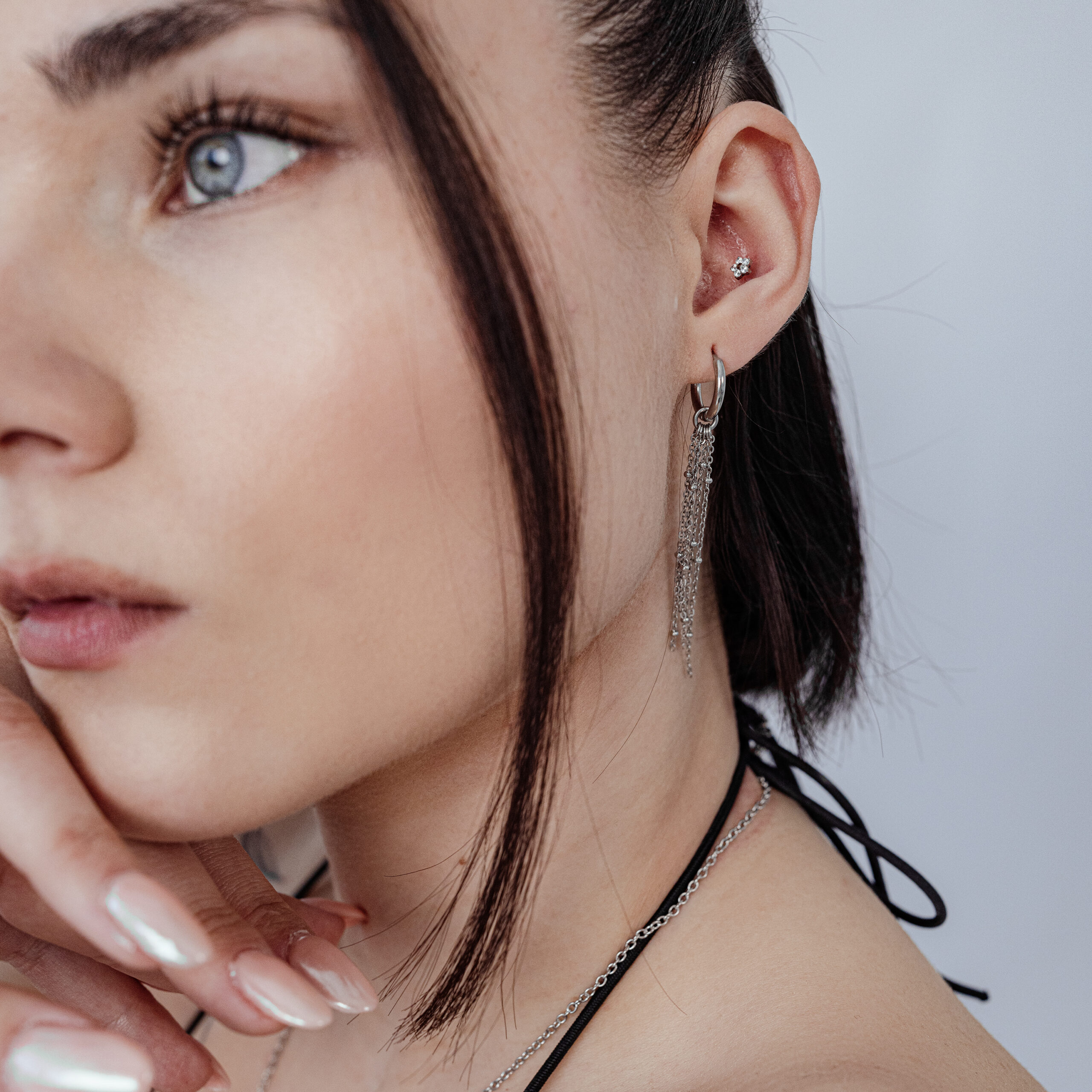 Donna con Push Fit Fiore nell'orecchio, collana e orecchini d'argento, sfondo bianco