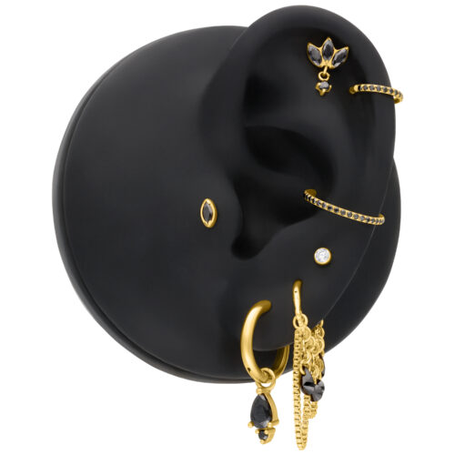 Punta per piercing dorata con cristallo nero diamante su modello di orecchio nero