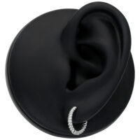 Piccoli orecchini d'argento intrecciati su un modello di orecchio nero su sfondo bianco