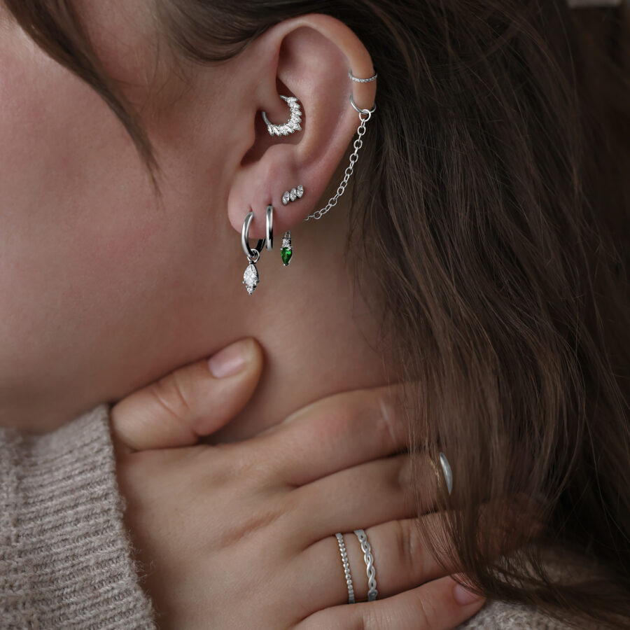Donna indossa orecchini Little Tear Hoops in acciaio chirurgico in vari colori e dimensioni.