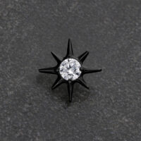 Perno a stella in metallo nero con cristallo chiaro su sfondo grigio