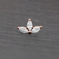 Attacco Lotus in rosé gold con tre cristalli chiari su sfondo grigio