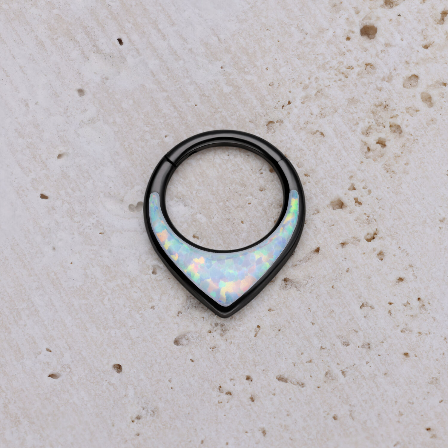 Clicker per setto nero con opale bianco su sfondo chiaro