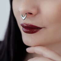 Clicker al setto nero con opale sintetico indossato al naso