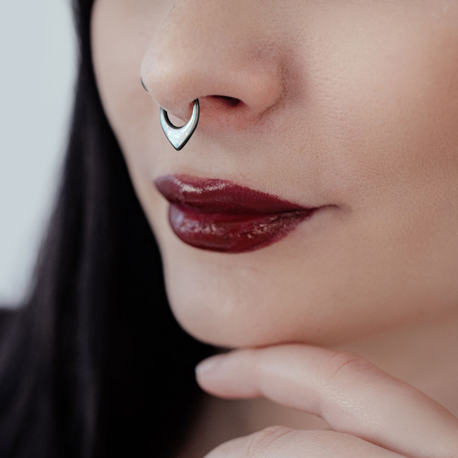 Clicker al setto nero con opale sintetico indossato al naso