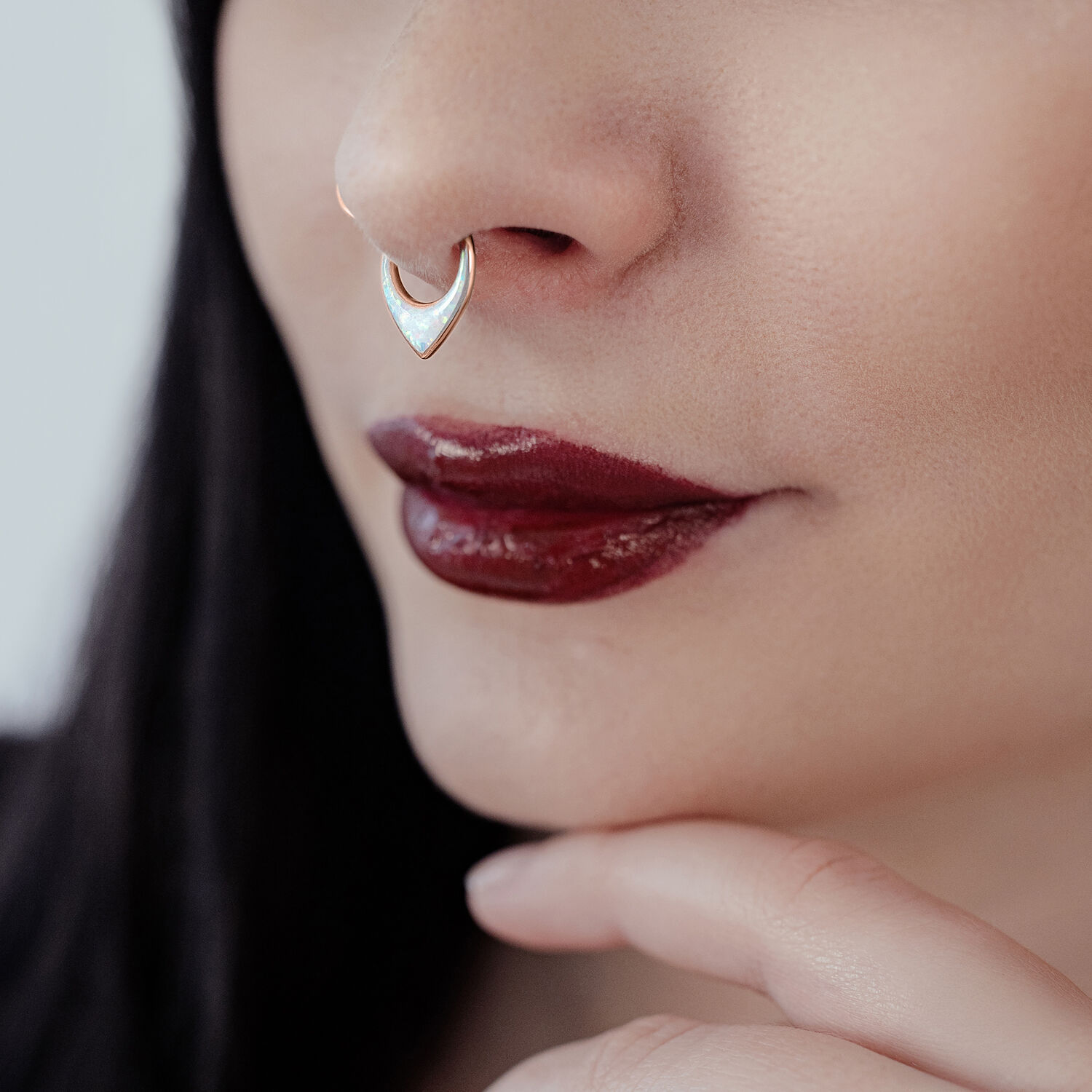 Primo piano di un Septum Clicker in oro rosa con opale sintetico su un naso