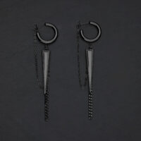 Due orecchini a triangolo neri con catene su sfondo scuro