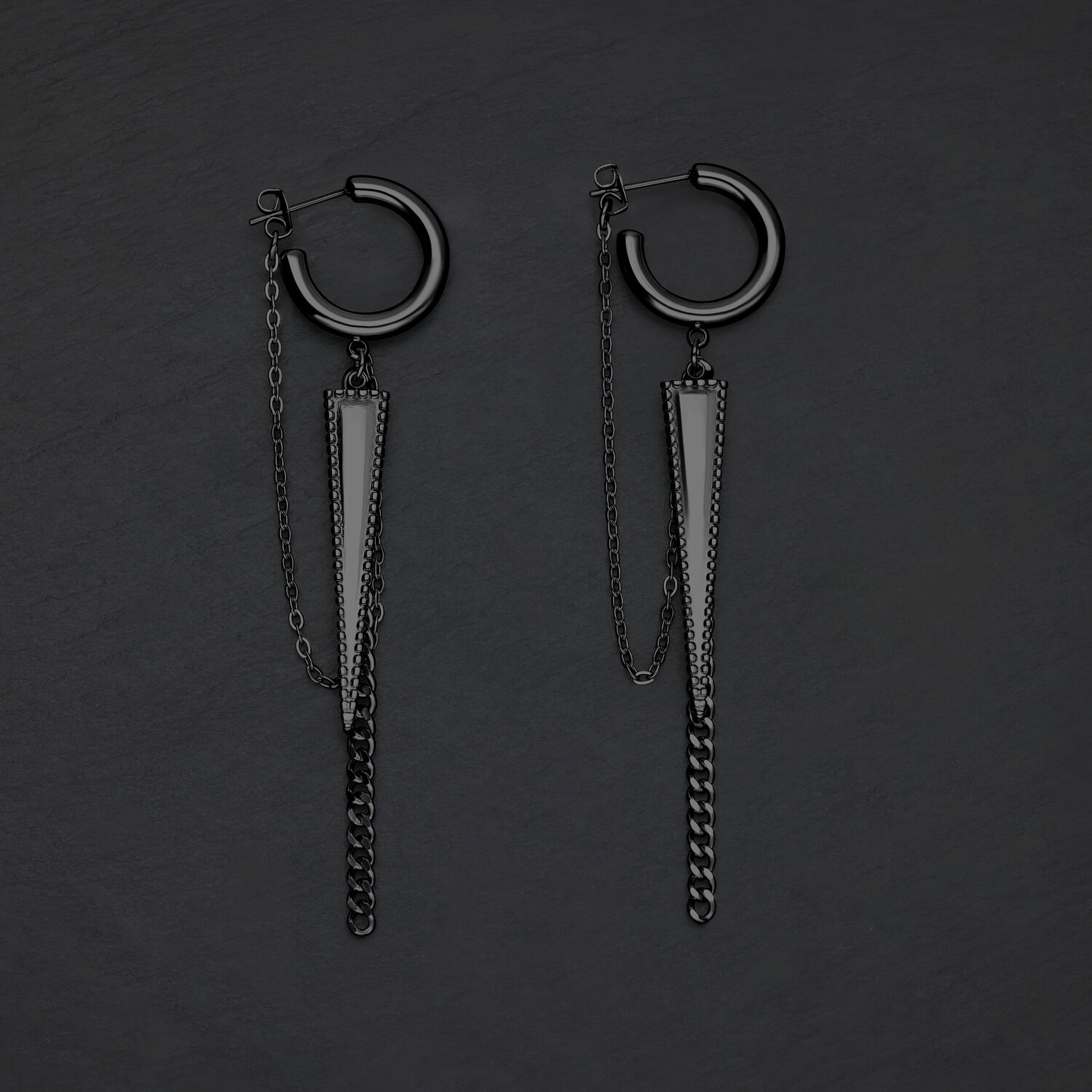 Due orecchini a triangolo neri con catene su sfondo scuro