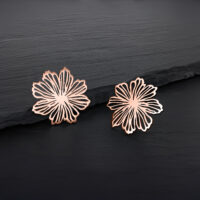 Due orecchini a fiore in oro rosa su sfondo nero