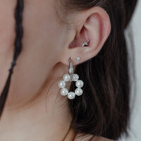 Orecchini d'argento con perle a forma di cerchio, indossati a un orecchio