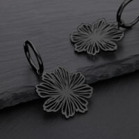 Orecchini a fiori neri in acciaio chirurgico su sfondo grigio