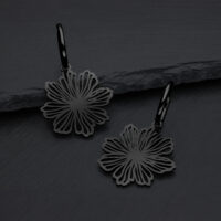 Orecchini neri a forma di fiore in acciaio chirurgico su sfondo grigio