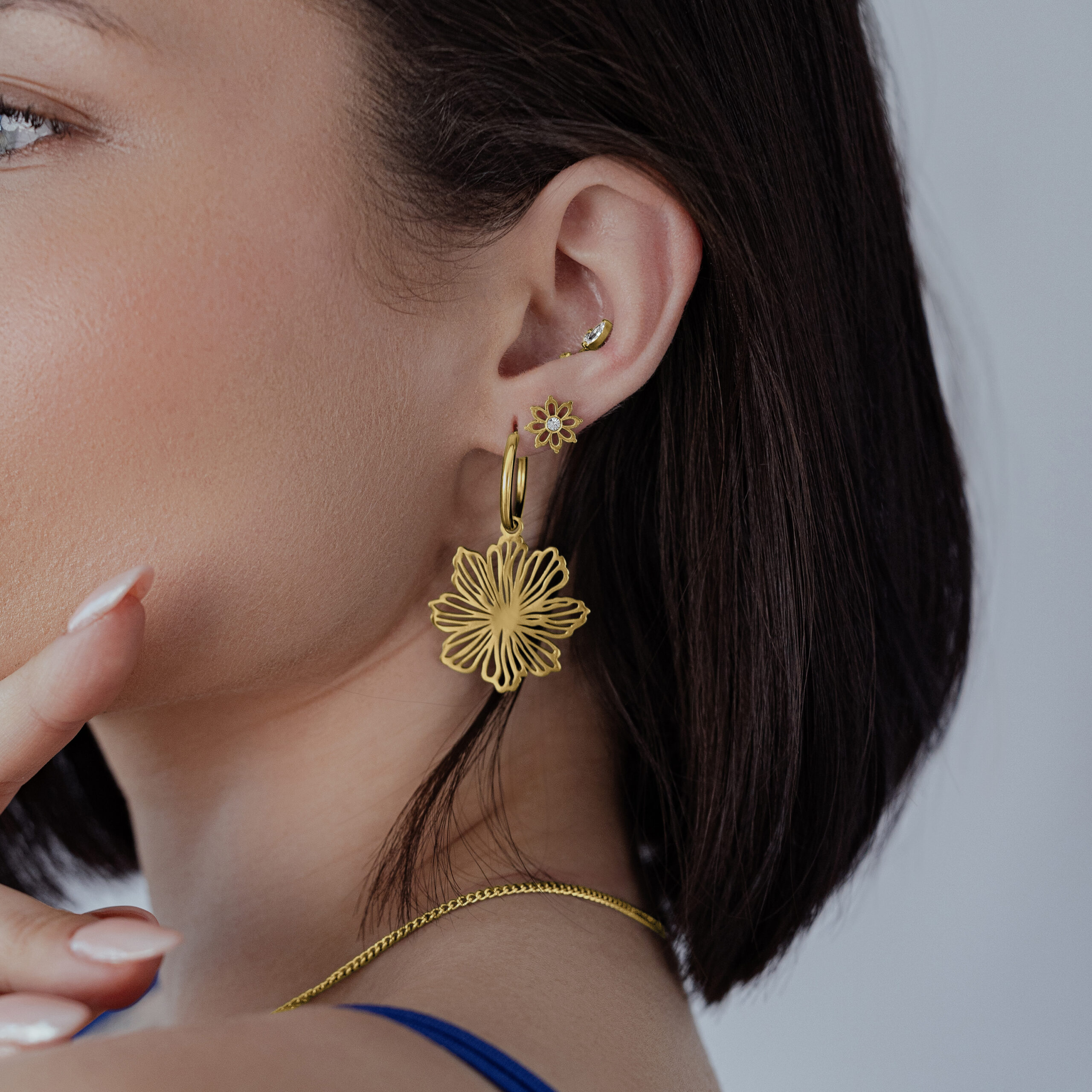 Orecchini Gold Fine Flower Hoops Donna indossa orecchini Gold Fine Flower Hoops su sfondo neutro