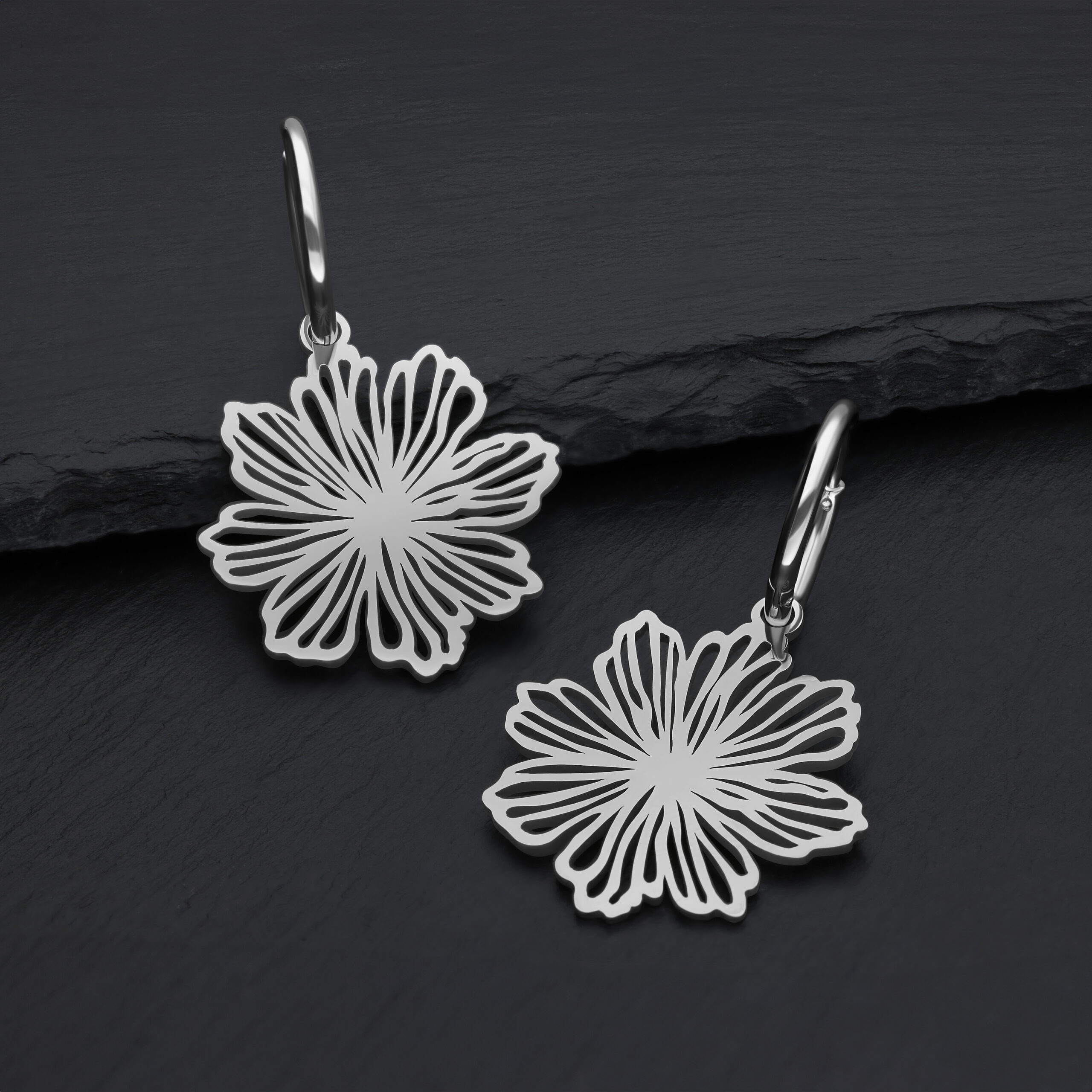 Orecchini in acciaio inossidabile argentati con design floreale su sfondo scuro