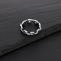 Anello a catena argentato in acciaio chirurgico su sfondo nero