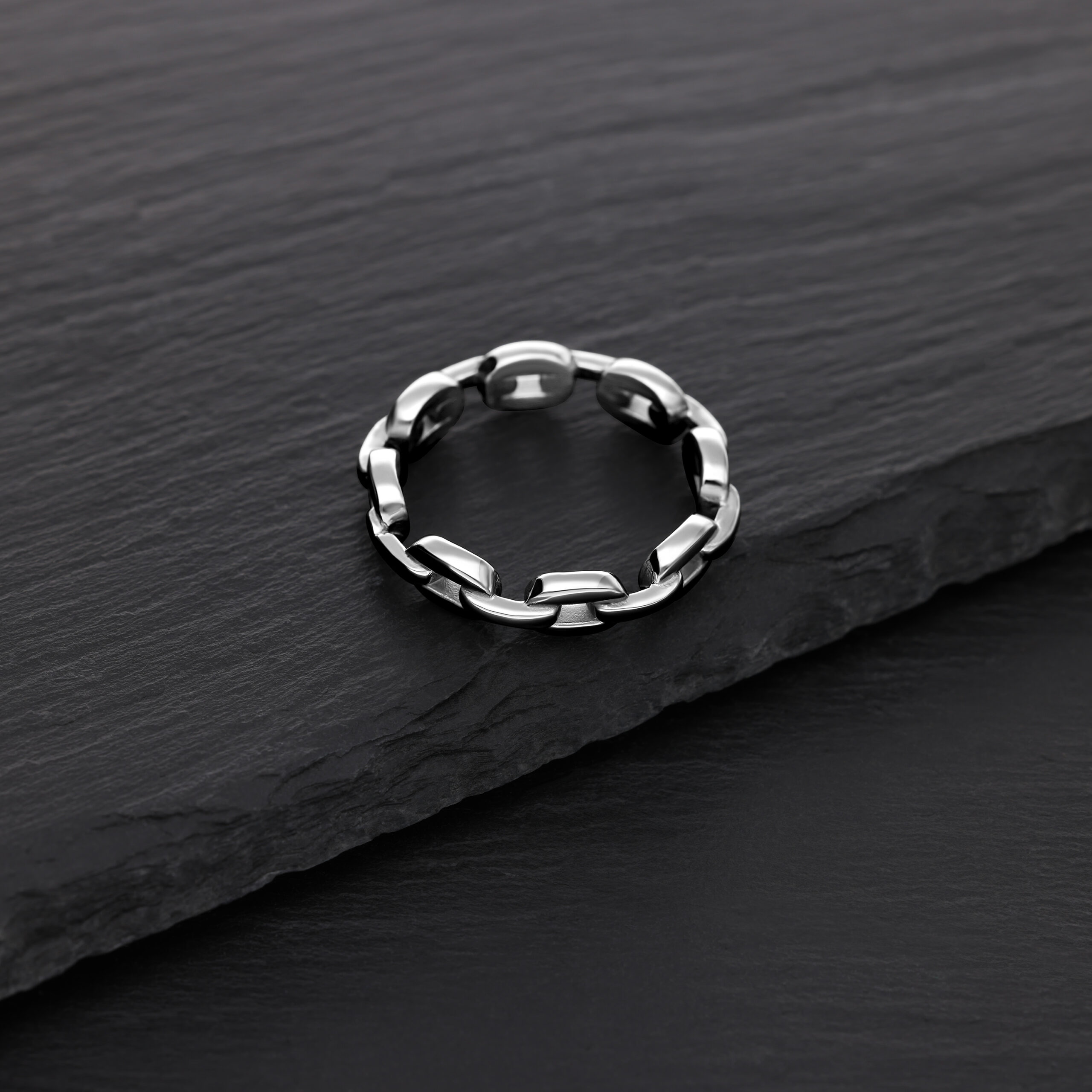 Anello a catena argentato in acciaio chirurgico su sfondo nero