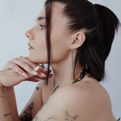 Donna con orecchini a cerchio Little Satellite in argento, profilo laterale, capelli raccolti