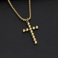 Collana Bubble Cross in Oro Collana Bubble Cross in acciaio chirurgico dorato su sfondo nero