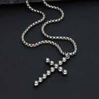 Collana a croce argento con design a sfere su sfondo nero