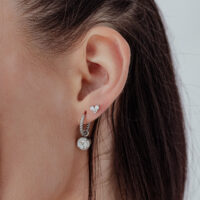 Cuore d'argento con pietra cristallina all'orecchio, vista laterale