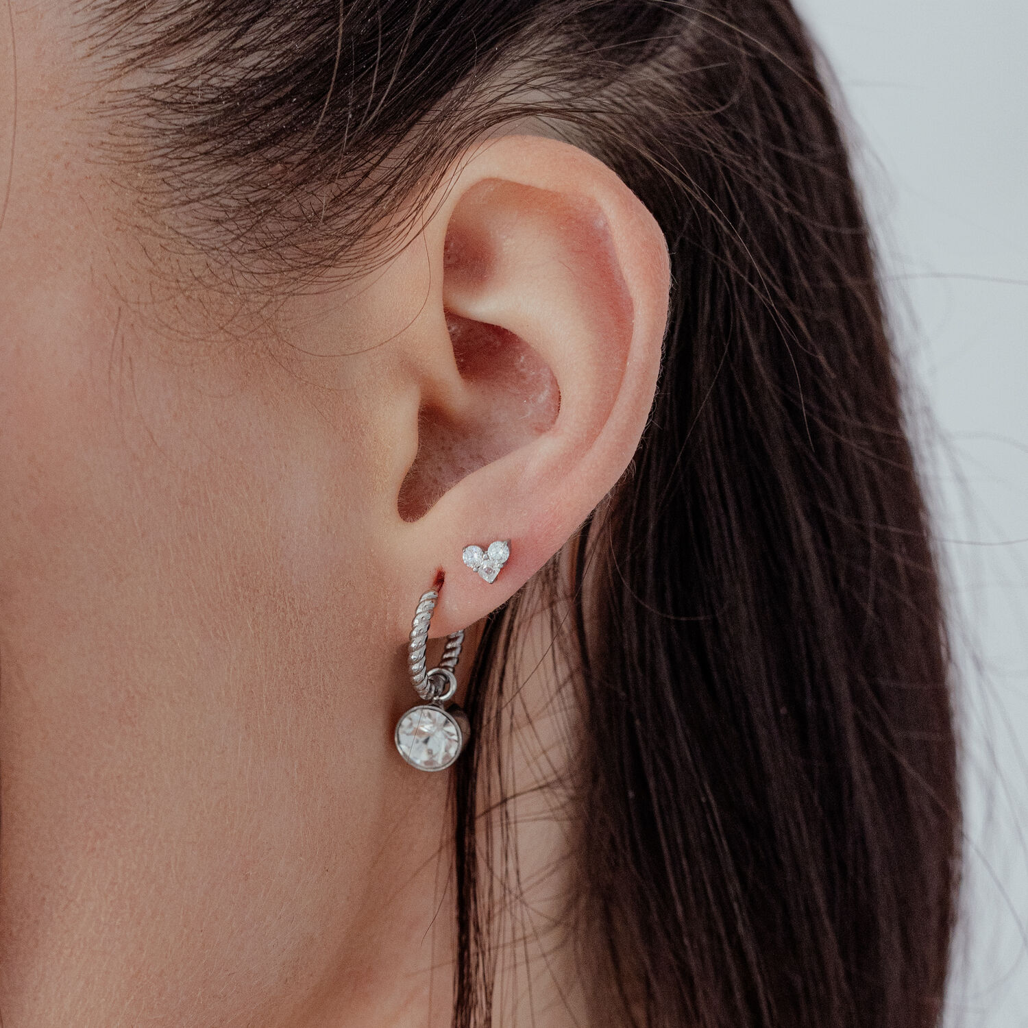 Cuore d'argento con pietra cristallina all'orecchio, vista laterale