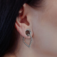 Bubble Polygon Hoops in argento all'orecchio di una persona