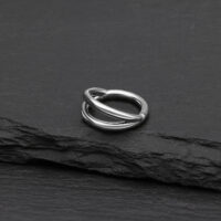 Anello clicker argento a doppia fila in titanio su sfondo nero