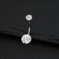 Piercing all'ombelico in argento con cristallo chiaro su sfondo nero