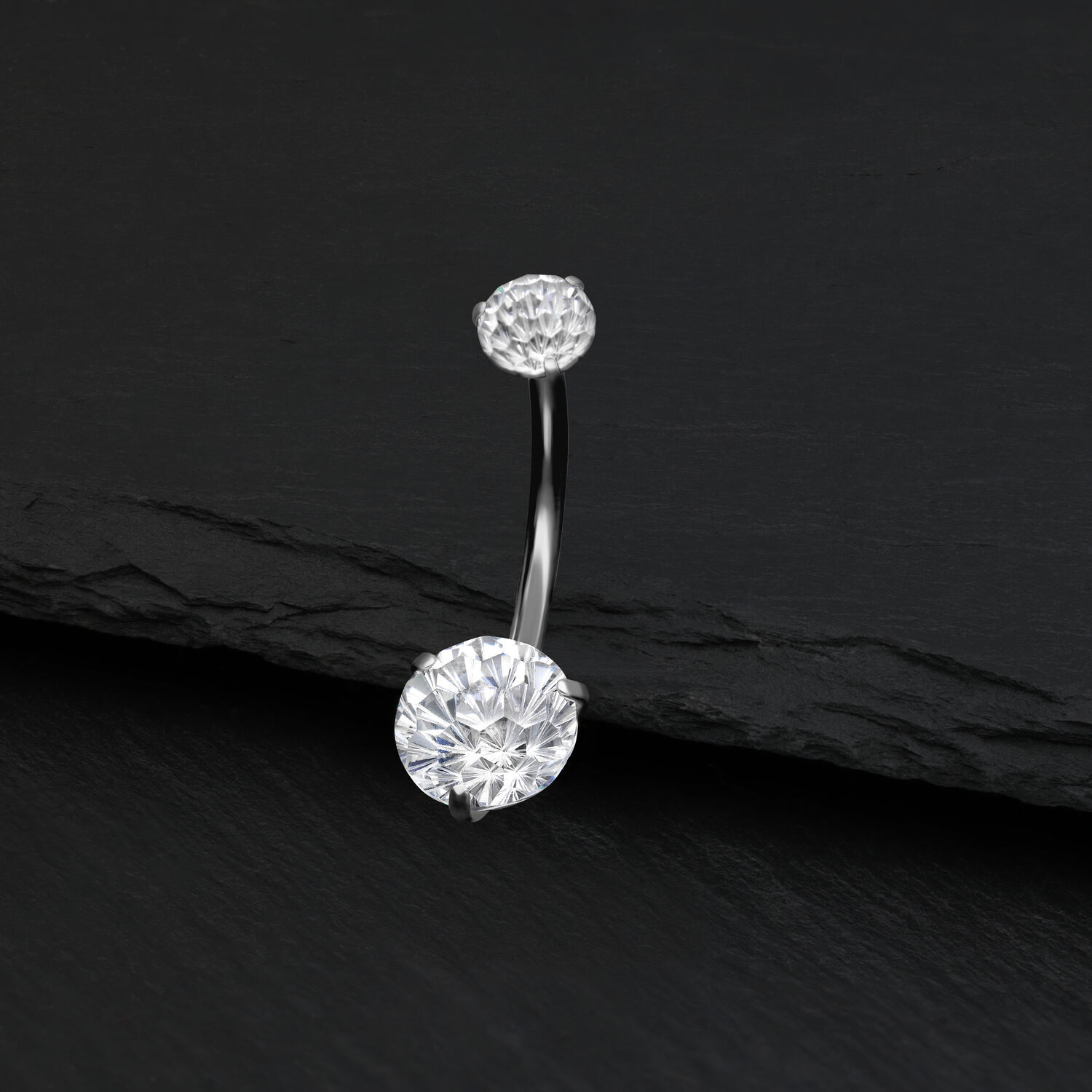 Piercing all'ombelico in argento con cristallo chiaro su sfondo nero