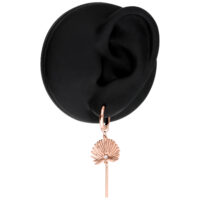 Orecchini in oro rosa su modello di orecchio nero in studio