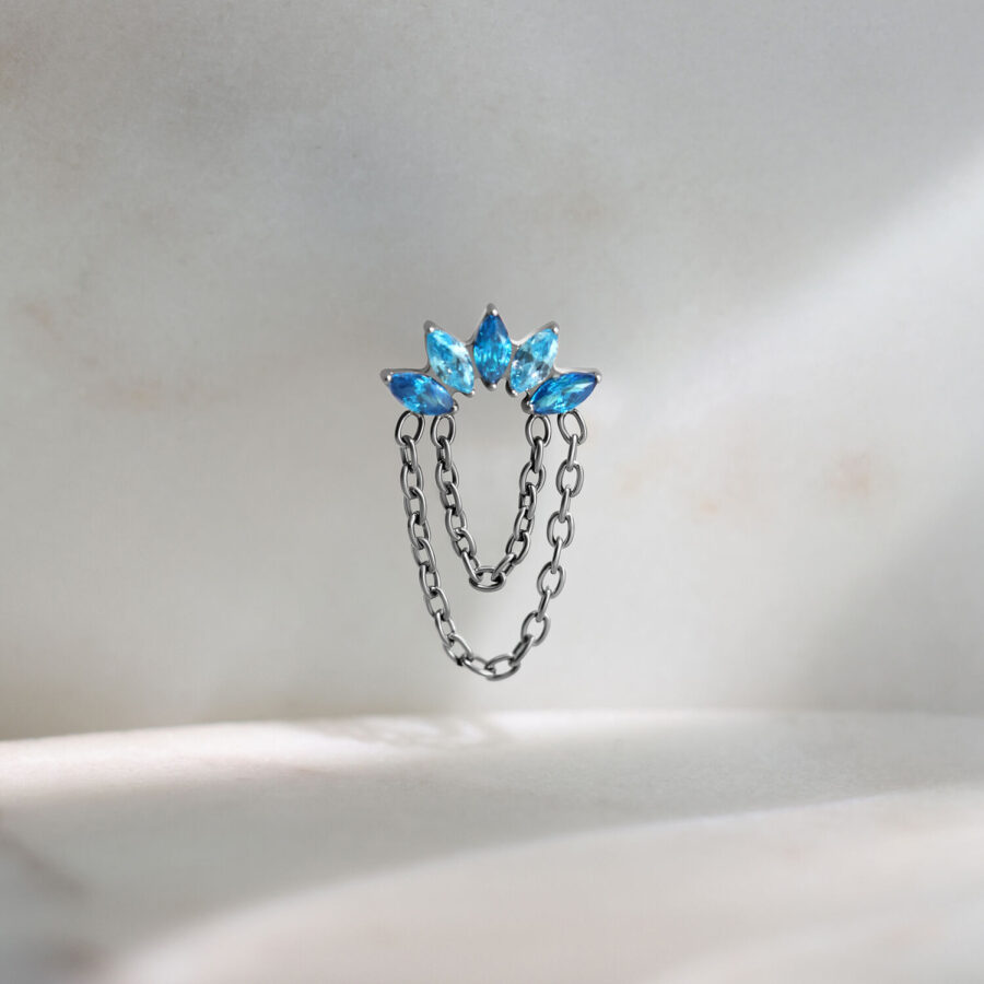 Attacco piercing Push Fit color argento con tre cristalli turchesi su sfondo chiaro