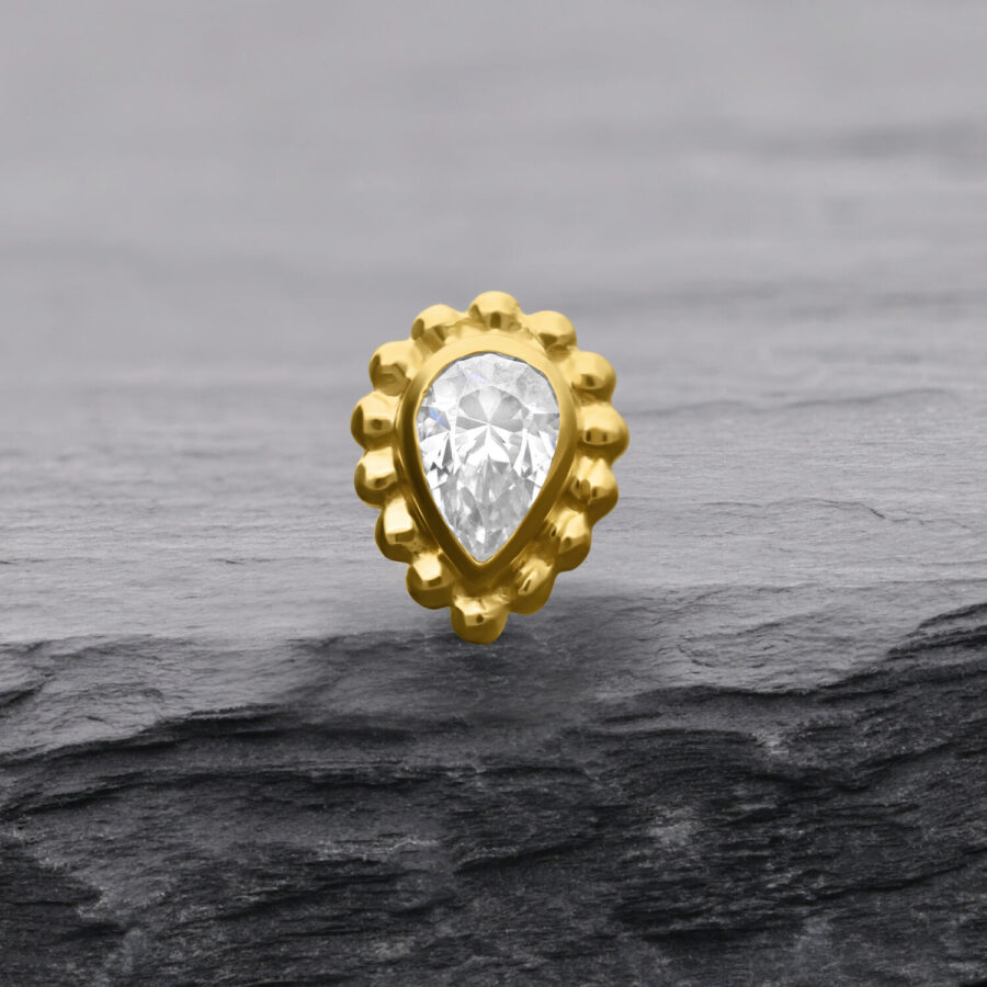 Attacco in oro 14K con cristallo a goccia su sfondo grigio