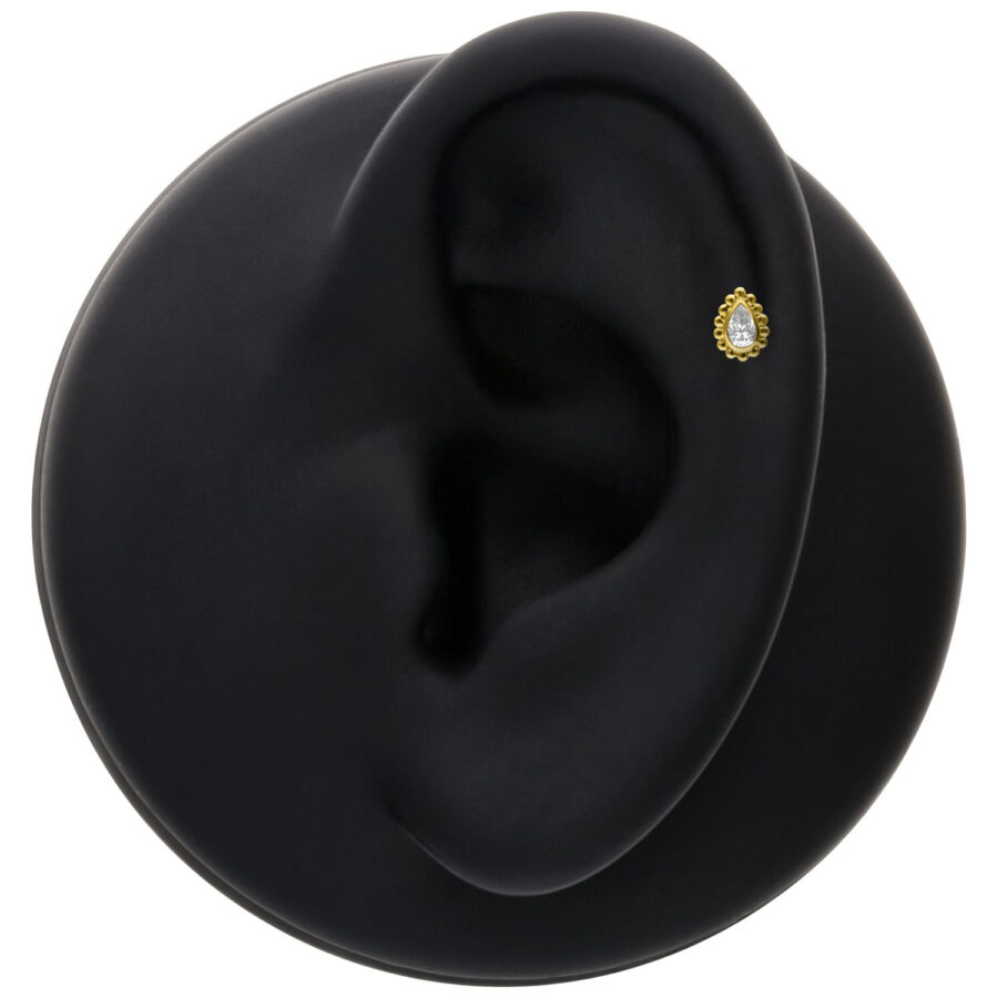Accessorio dorato con goccia di cristallo su modello di orecchio nero