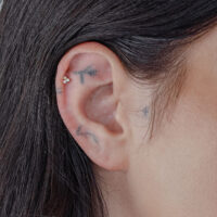 Accessorio in oro con opale sintetico in un piercing all'orecchio.