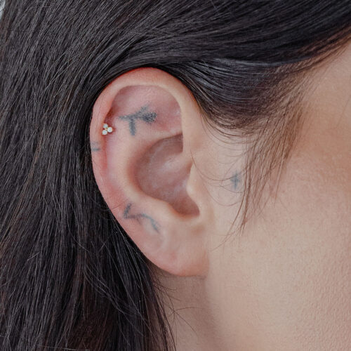 Accessorio in oro con opale sintetico in un piercing all'orecchio.