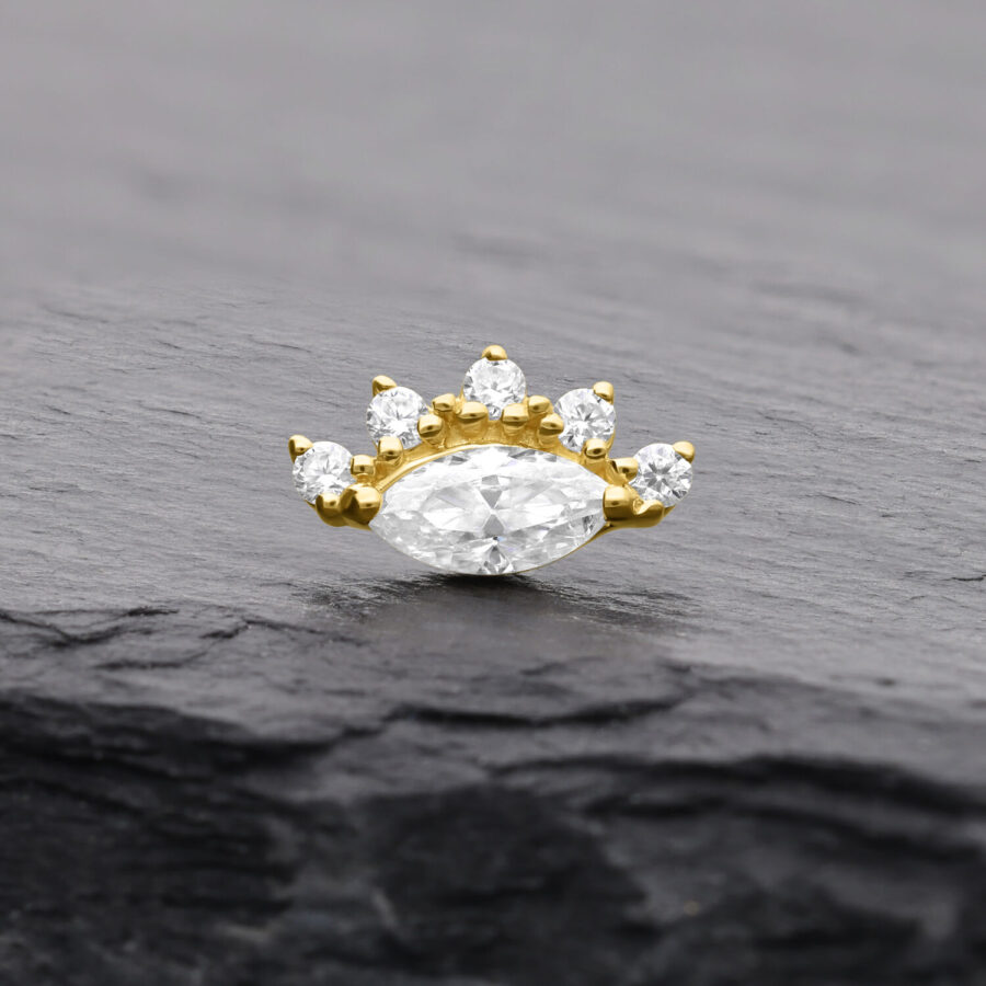 Attacco in oro con moissanite e cinque pietre su sfondo scuro