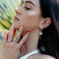 Donna con diversi orecchini, tra cui Little Petticoat Hoops, all'orecchio, all'aperto