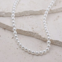 Collana di perle in argento in acciaio chirurgico su sfondo chiaro