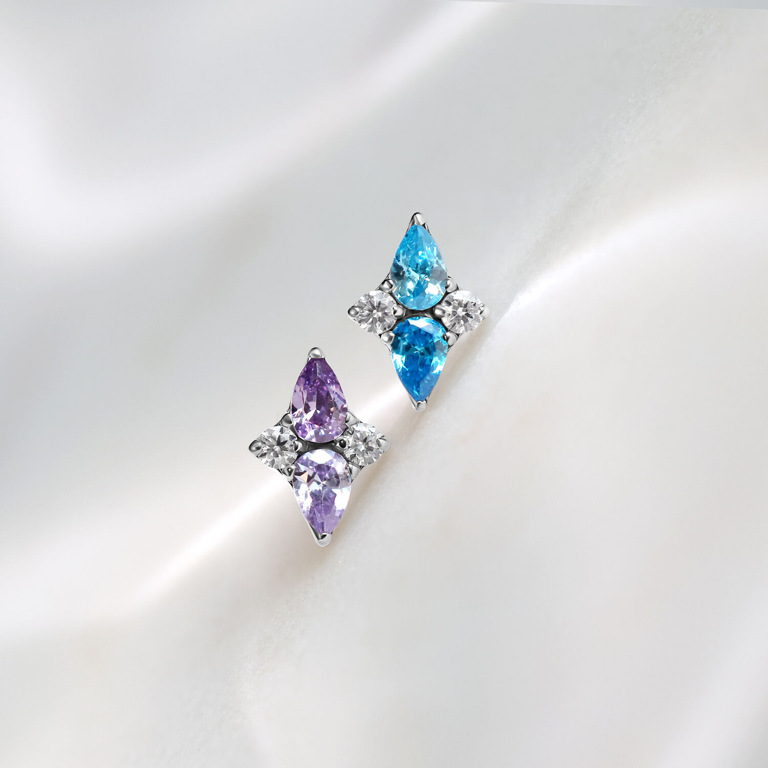 Due inserti Push Fit in titanio color lavanda e turchese su sfondo bianco