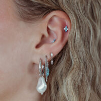 Orecchio con più piercing, incluso un inserto Push Fit argento con cristallo turchese
