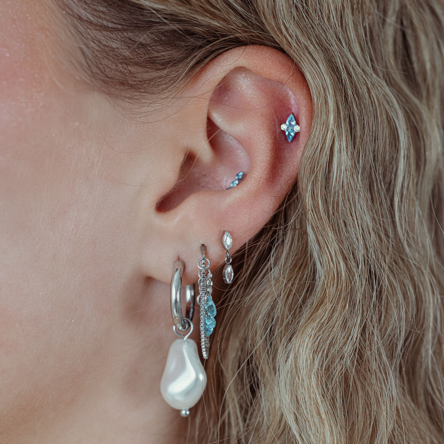 Orecchio con più piercing, incluso un inserto Push Fit argento con cristallo turchese
