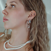 Donna con piercing all'orecchio in argento e cristalli, primo piano