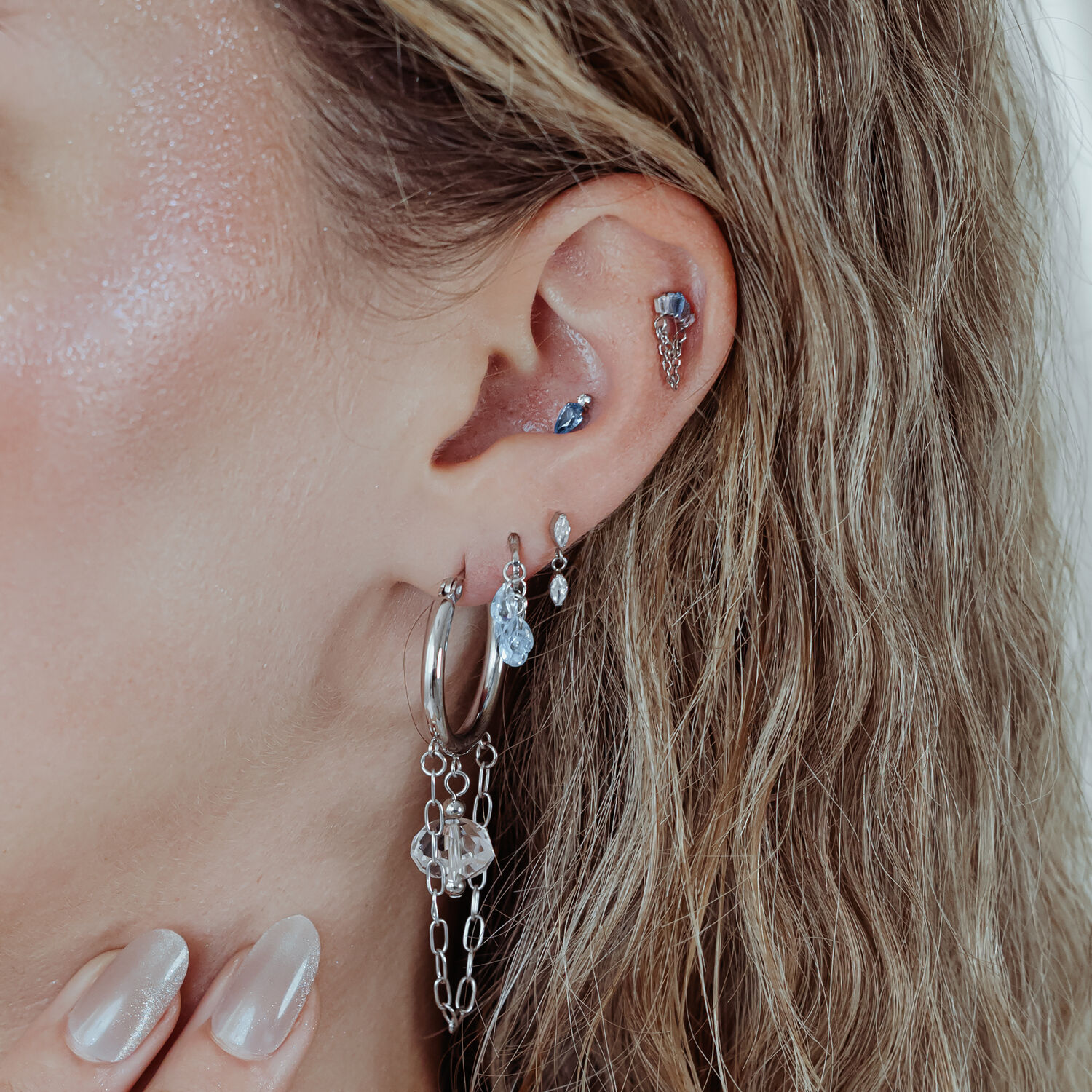 Orecchio con più piercing, incluso un Mystic Dew in argento
