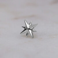 Silberner sternförmiger Aufsatz aus Titan auf hellem Hintergrund