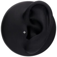 Accessorio argento a forma di stella in un modello di orecchio nero, ambiente studio